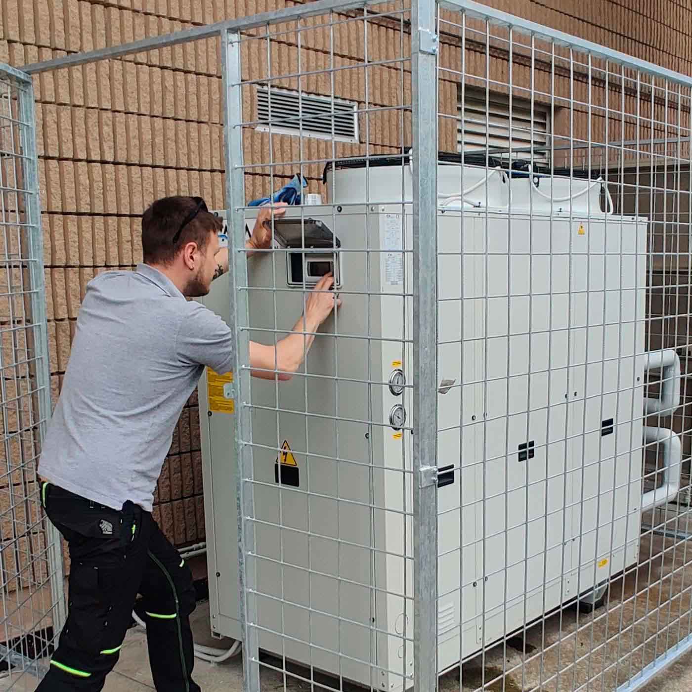 Tecnico-climaref_climatizzazione_industriale_macchina_esterna tecnico climaref lavora su macchina esterna di climatizzazione industrale